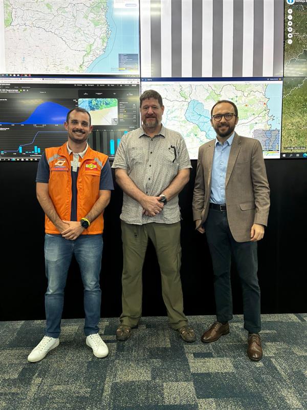 Foto de representantes da SPDC/SC, Fractal e do Departamento de Estado dos EUA durante visita técnica ao CIGERD, em Florianópolis, para troca de experiências em riscos climáticos